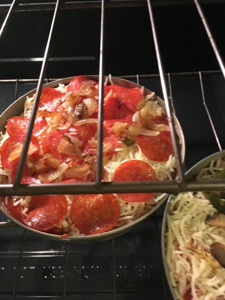 A pepperoni pizza in the oven before baking.