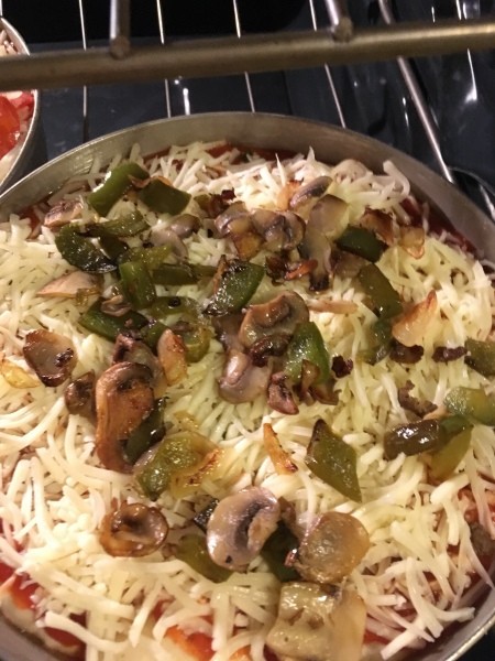 A pizza in the oven before baking.