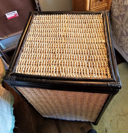 A wicker hamper with scratches colored in with a black Sharpie.