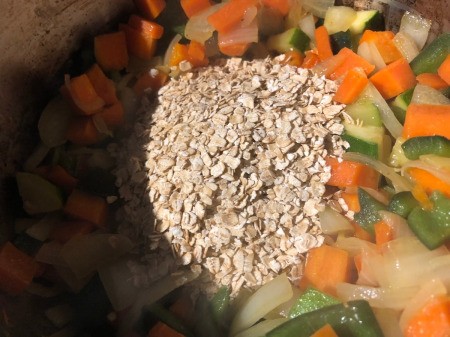 adding oats to the middle of the cooking vegetables