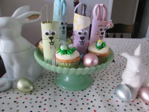 Recycled Bunny Friends - cake plate with bunnies among the cupcakes surrounded by two white ceramic bunnies and plastic eggs