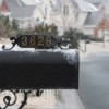 A house number on a mailbox in the snow.