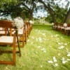 An outdoor wedding with white petals down the center.