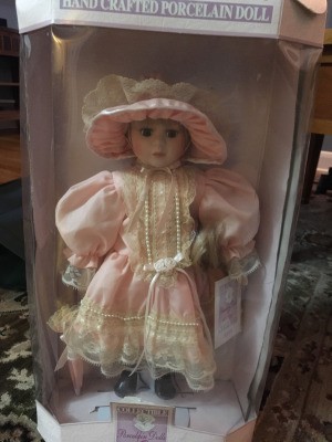 Value of a Collectible Memories Porcelain Doll - doll in pink drop waist period dress with matching hat
