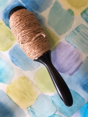 A recycled lint roller being reused as a twine dispenser.