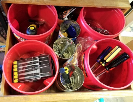 Coffee tubs and other recycled containers being used for organizing tools.