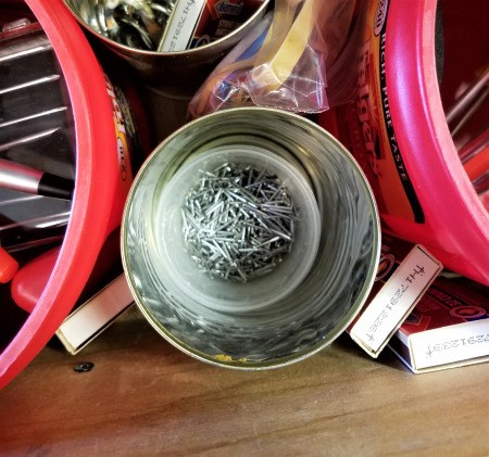Coffee tubs and other recycled containers being used for organizing tools.