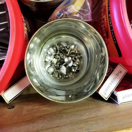 Coffee tubs and other recycled containers being used for organizing tools.