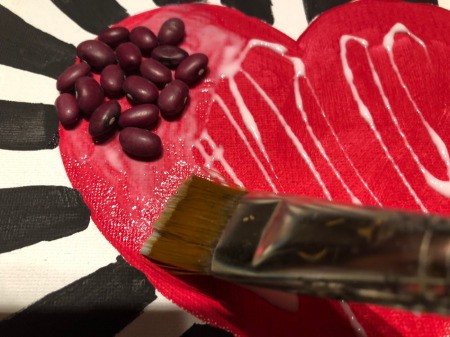 Making a Mural from Beans - spread the glue around and add the beans of a matching color
