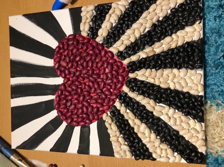 Making a Mural from Beans - continue glueing the beans onto the colored areas
