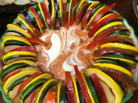colorful veggie slice around outside of round baking dish