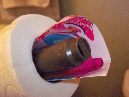 A paper scented perfume sample inside a roll of toilet paper.