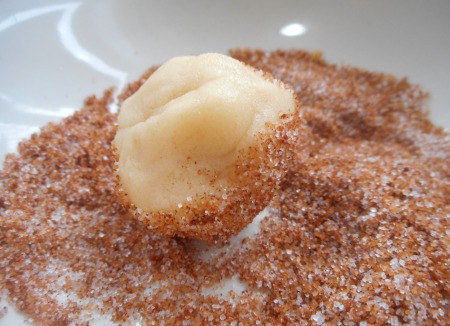 rolling ball of dough in cinnamon/sugar mixture