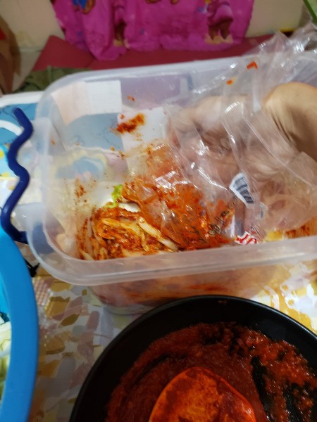 mixing kimchi with covered hand