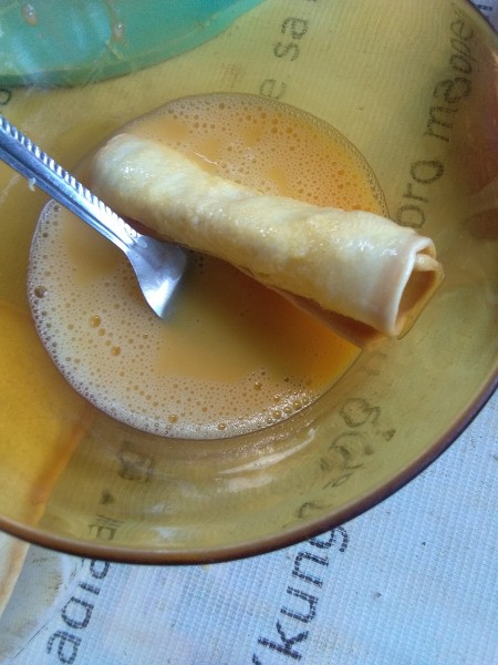coating bread roll with beaten egg