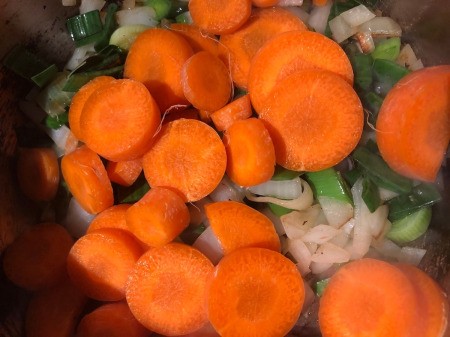 carrots added to onions in pan