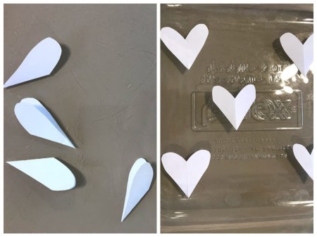 Crafting Supplies from Baking Soda and Vinegar Experiment - paper heart shapes cut out and then placed in glass baking dish