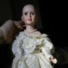 Identifying a Porcelain Doll - hairless doll wearing a pretty lacy dress and pearls