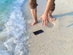 A phone dropped in the surf at the beach.