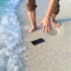 A phone dropped in the surf at the beach.