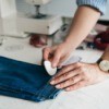 A person marking the hemline of jeans in order to alter them.