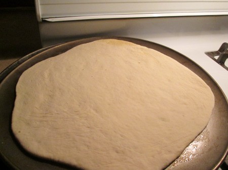 flattened Pizza Dough on pan