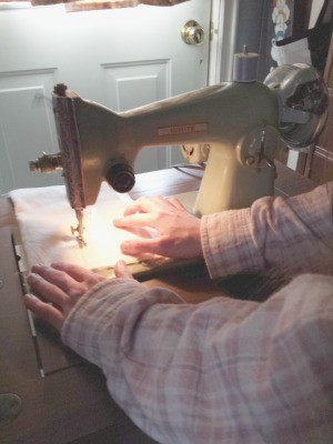 Value of a 7012 White Sewing Machine - dark photo of a person using the machine