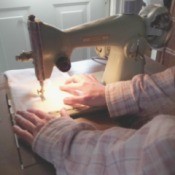 Value of a 7012 White Sewing Machine - dark photo of a person using the machine