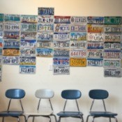A collection of license plates on a wall at the DMV.