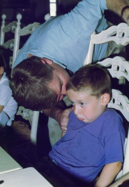 A father talking to his son at a party.