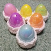 Crocheted Easter Egg Cups - 6 plastic eggs sitting in white crochet egg cups