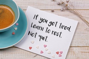 'If you get tired learn to rest not quit' written on a note near a teacup.