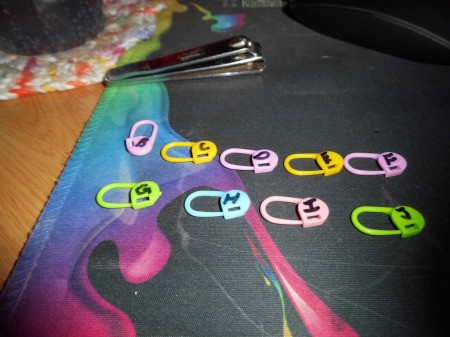 A collection of colored stitch markers with numbers denoted.