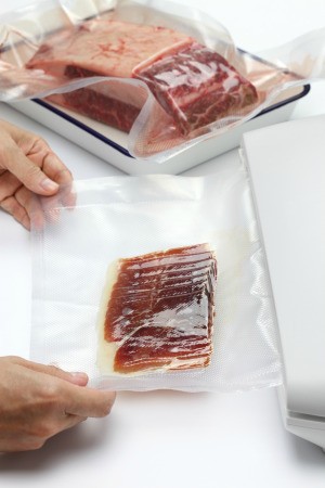 Vacuumed sealed bags of meats in a kitchen.