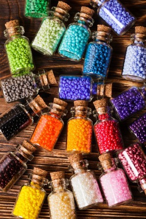 Colorful beads in small glass jars.