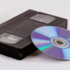A VHS tape next to a DVD disk.