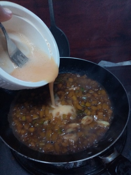 adding beaten egg to pan