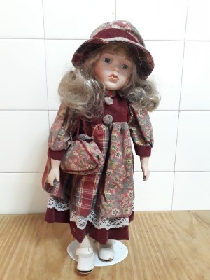 Identifying a Porcelain Doll - doll wearing a floral and plaid dress with matching hat