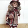 Identifying a Porcelain Doll - doll wearing a floral and plaid dress with matching hat