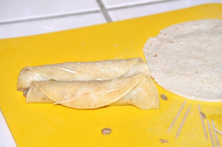 Rolled up taquitos with toothpicks.