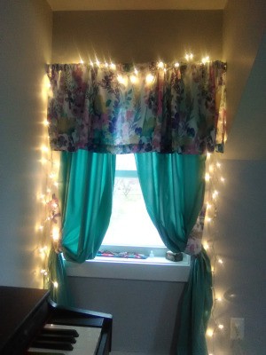 A window treatment with white Christmas "fairy" lights framing it.