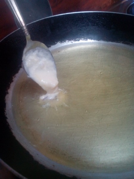 spoon of dough added to hot oil
