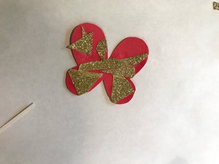 Making a Kid's Paper Butterfly Bracelet - red butterfly with gold paper bits as decorations