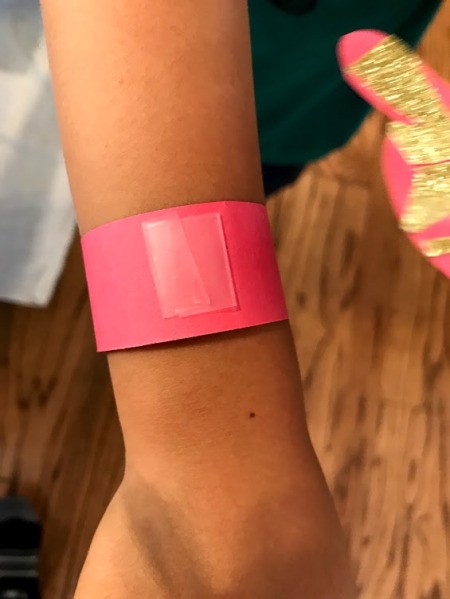 Making a Kid's Paper Butterfly Bracelet - add tape to front of paper strip to attach butterfly