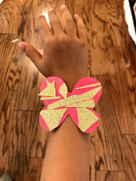 Making a Kid's Paper Butterfly Bracelet - child wearing the red butterfly