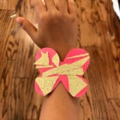 Making a Kid's Paper Butterfly Bracelet - child wearing the red butterfly
