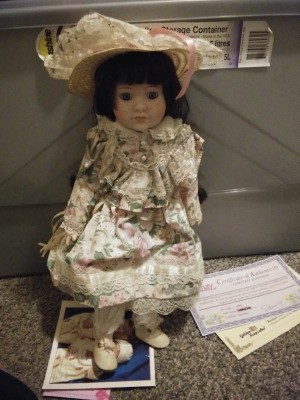Identifying a Porcelain Doll - doll wearing a floral dress and straw hat