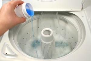 Blue liquid being poured into a dish washer.