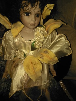 Identifying Porcelain Dolls - doll wearing a satin dress with yellow lily petals