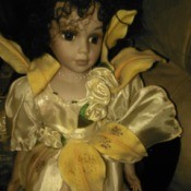 Identifying Porcelain Dolls - doll wearing a satin dress with yellow lily petals